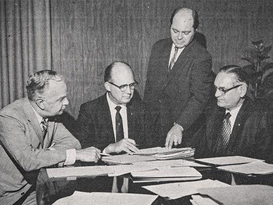 Founders gathered around a table looking at documents